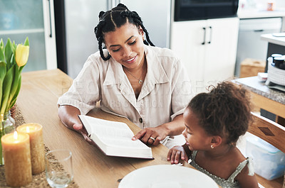 Buy stock photo Shot of a mother teaching her daughter about the bible at home