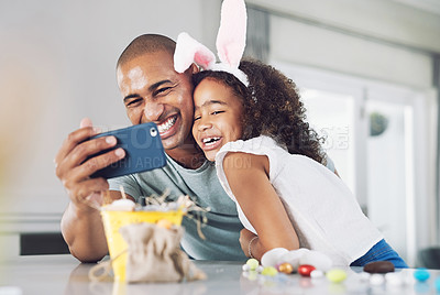 Buy stock photo Shot of a father and daughter taking a selfie at home