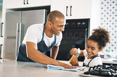 Buy stock photo Shot of a young man cleaning a surface with a child at home