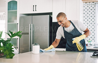 Buy stock photo Shot of a young man wiping a surface at home