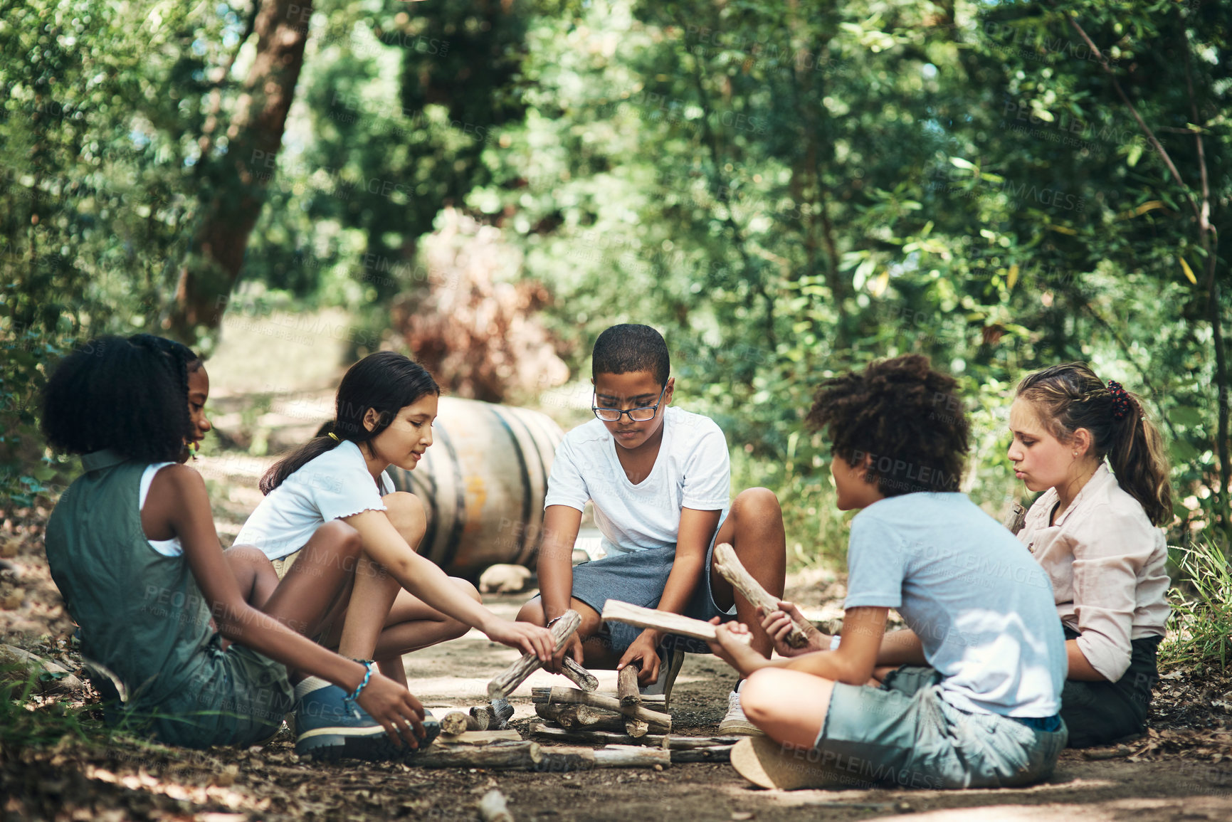 Buy stock photo Shot of a group of teenagers building a pile of wood at summer camp