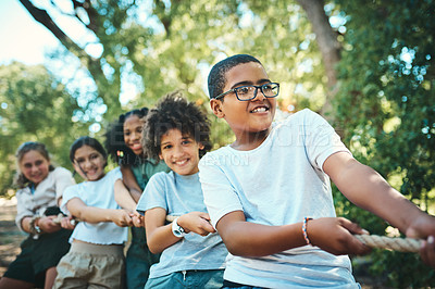 Buy stock photo Shot of a group of teenagers playing a game of tug of war at summer camp