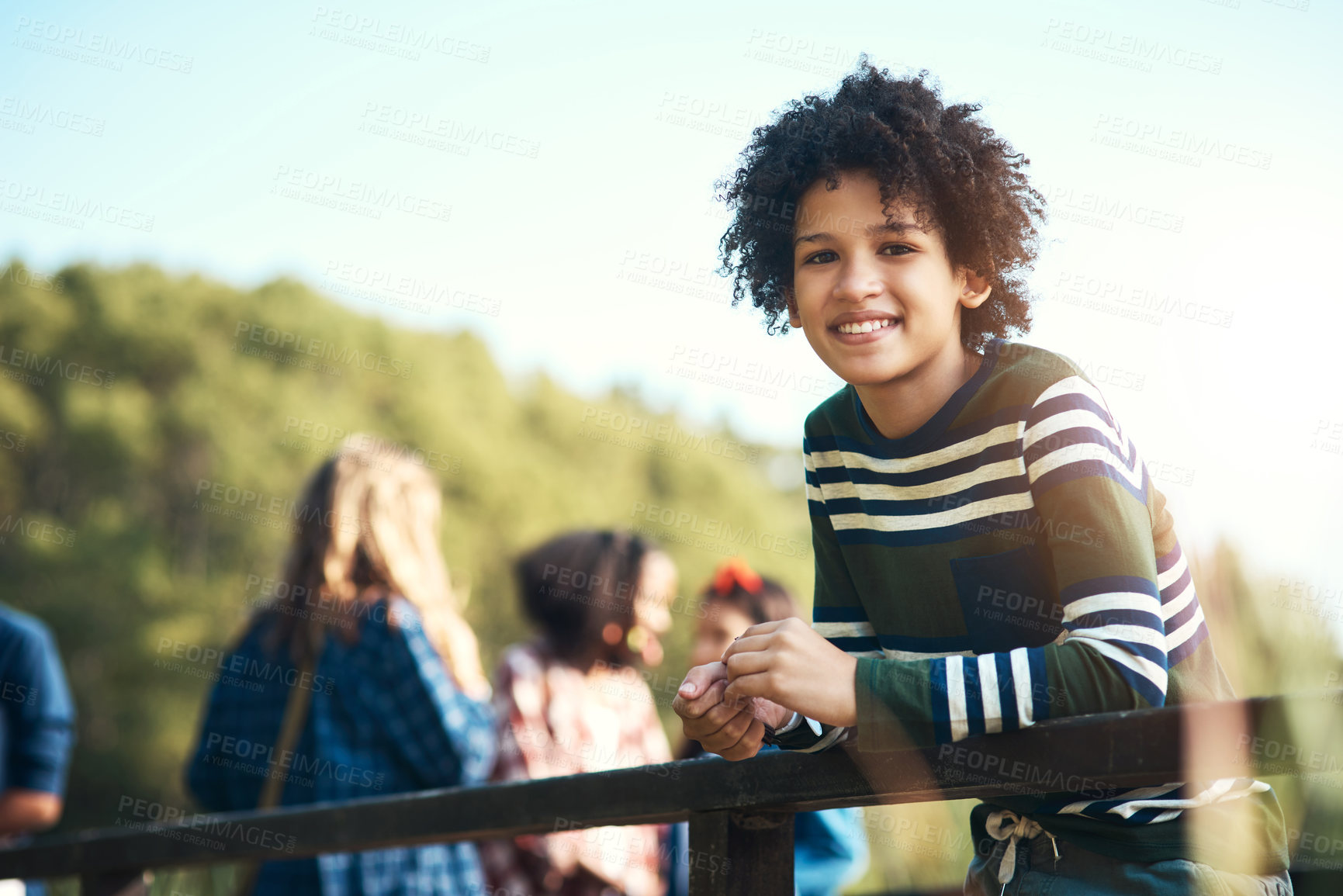 Buy stock photo Shot of a teenager boy standing on a bridge in nature at summer camp