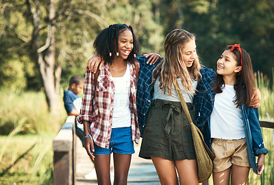 Buy stock photo Shot of a group of teenage girls walking and chatting in nature at summer camp