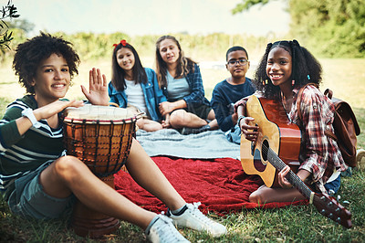 Buy stock photo Shot of a group of teenagers playing musical instruments in nature at summer camp