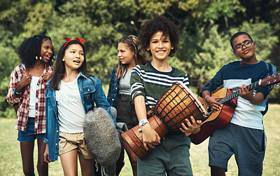 Buy stock photo Shot of a group of teenagers playing musical instruments in nature at summer camp