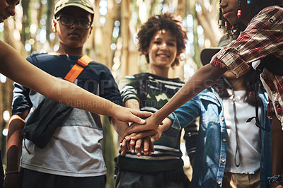 Buy stock photo Shot of a group of teenagers standing in a circle and joining their hands in solidarity at summer camp