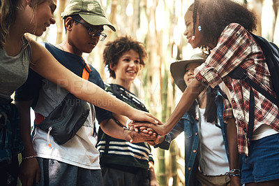 Buy stock photo Shot of a group of teenagers standing in a circle and joining their hands in solidarity at summer camp