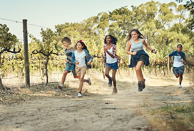 Buy stock photo Shot of a group of teenagers running through nature at summer camp