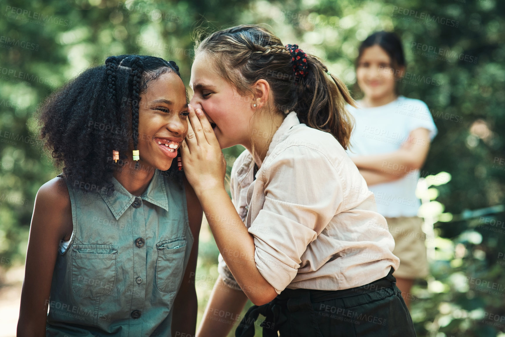 Buy stock photo Shot of two teenage girls gossiping about their friend at summer camp