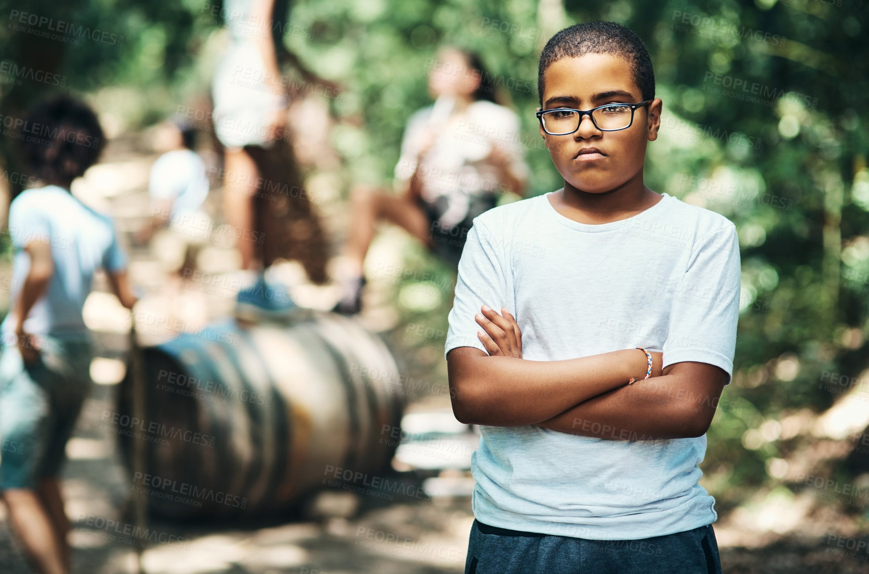 Buy stock photo Shot of a teenage boy looking unhappy at summer camp