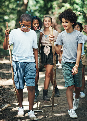 Buy stock photo Shot of a group of teenagers exploring nature together at summer camp