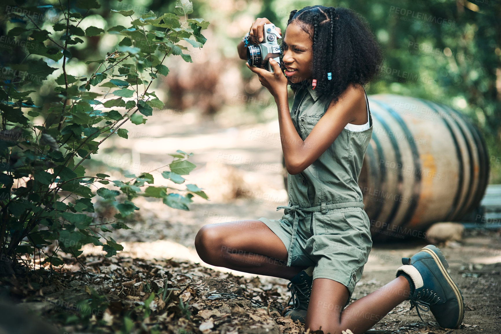 Buy stock photo Shot of a teenage girl using a camera while hiking through the forest at summer camp