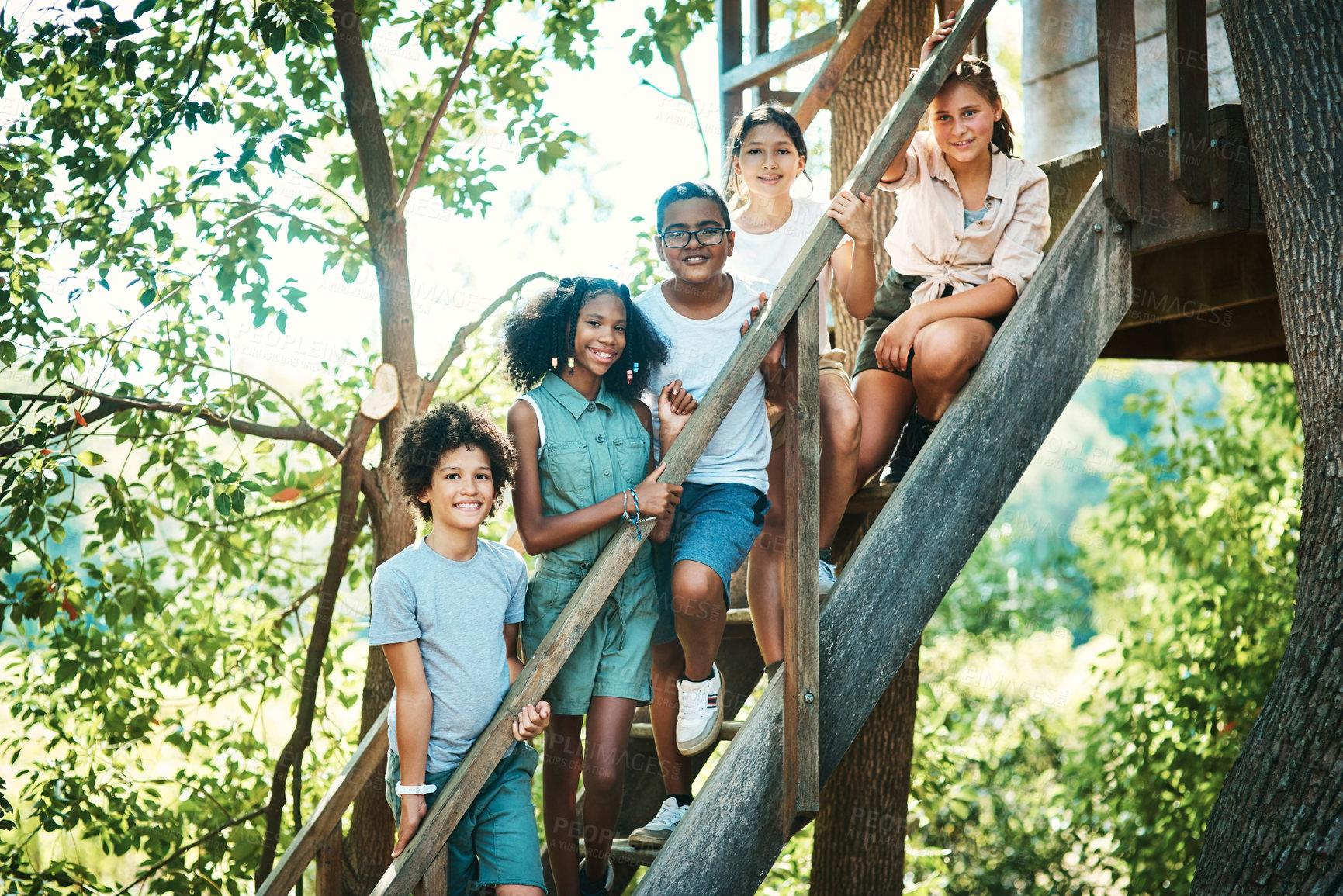 Buy stock photo Shot of a group of teenagers standing next to a treehouse at summer camp