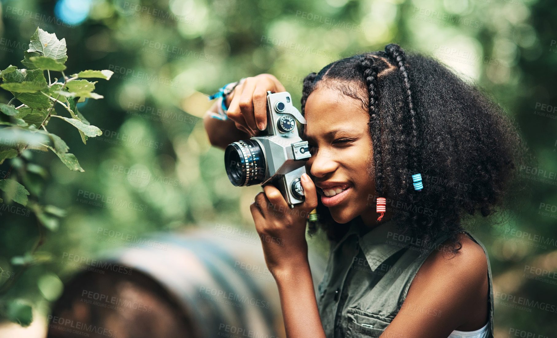 Buy stock photo Shot of a teenage girl using a camera while hiking through the forest at summer camp