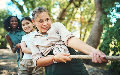 Buy stock photo Shot of a group of teenagers playing a game of tug of war at summer camp