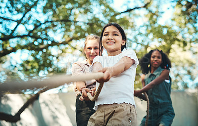 Buy stock photo Shot of a group of teenagers playing a game of tug of war at summer camp