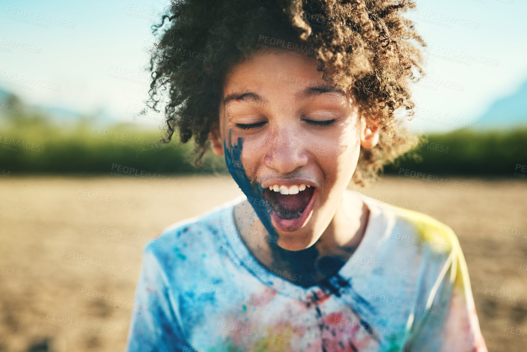 Buy stock photo Shot of a teenage boy having fun with colourful powder at summer camp