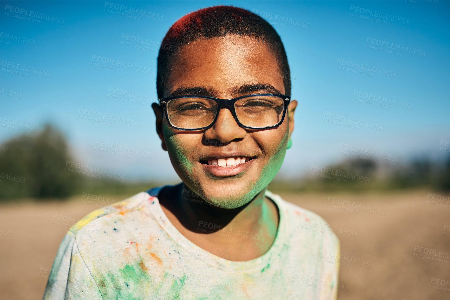 Buy stock photo Shot of a teenage boy having fun with colourful powder at summer camp