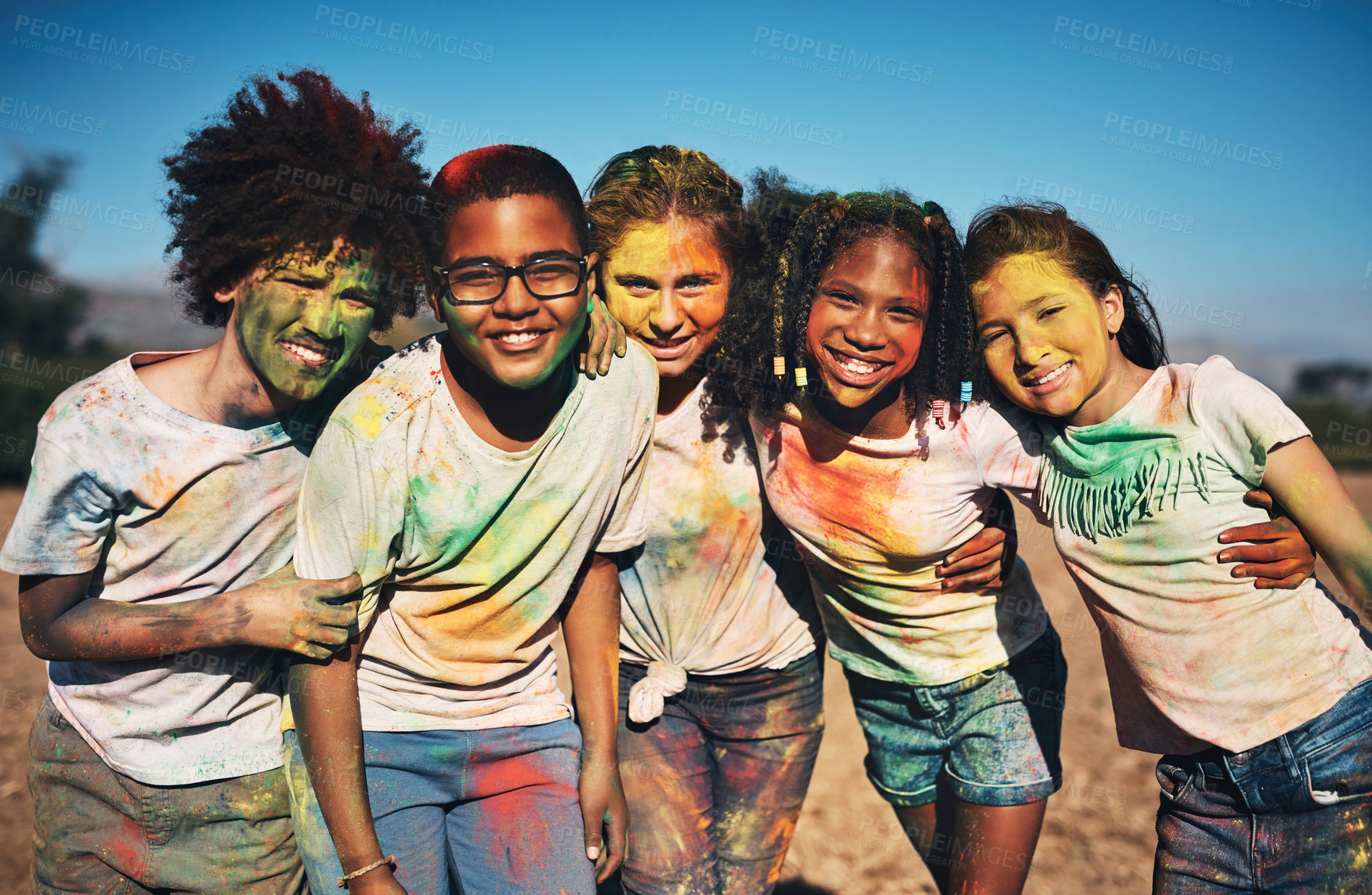 Buy stock photo Shot of a group of teenagers having fun with colourful powder at summer camp