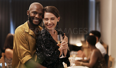 Buy stock photo Shot of a happy young couple standing close together during a New Year's eve dinner party
