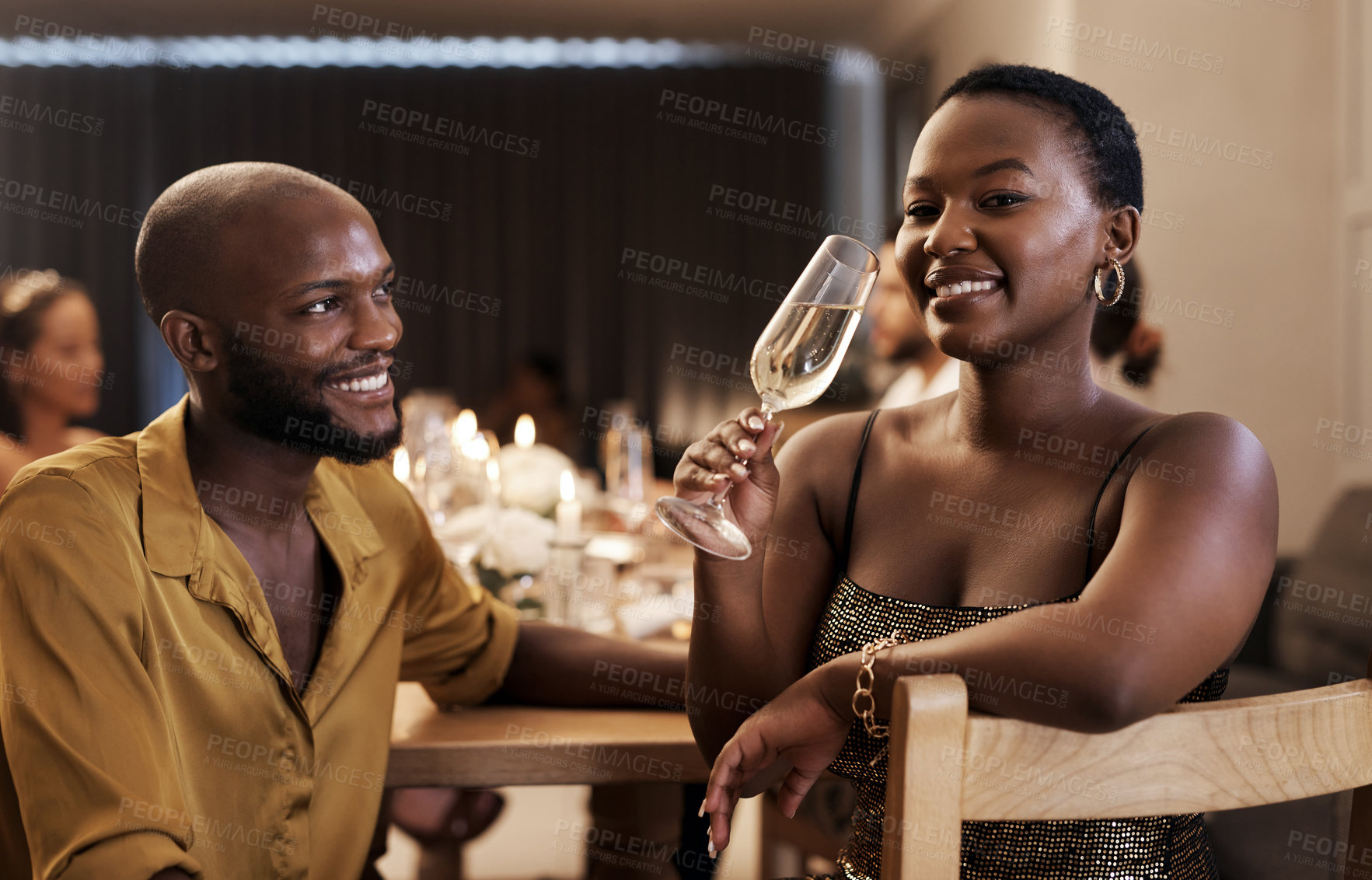 Buy stock photo Shot of an attractive young woman sitting with her boyfriend during a New Year's dinner party