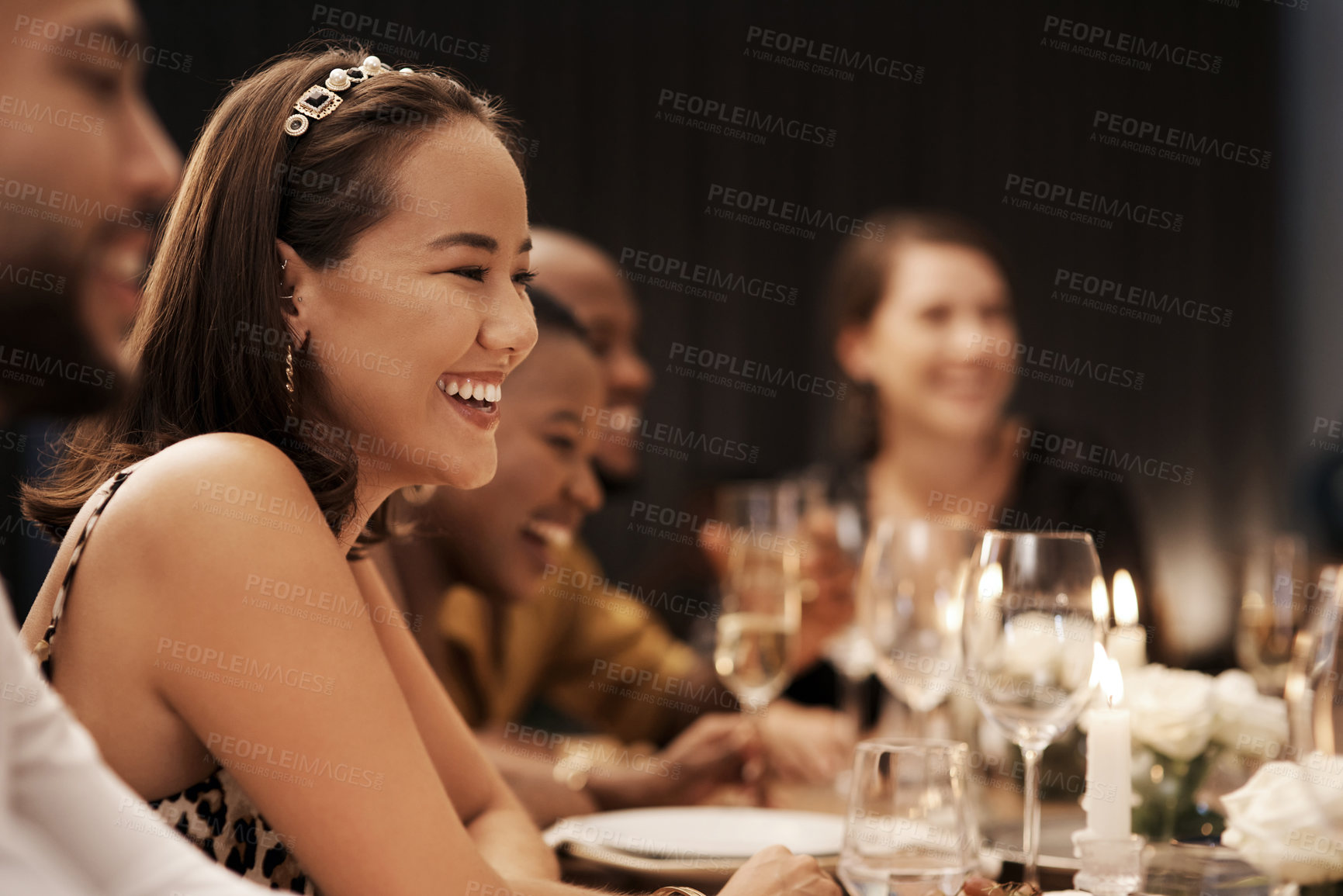 Buy stock photo Shot of an attractive young woman sitting and enjoying a New Year's dinner party with friends