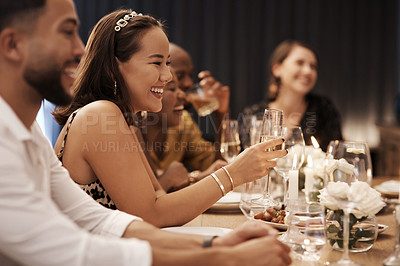 Buy stock photo Shot of an attractive young woman sitting and enjoying a New Year's dinner party with friends