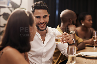 Buy stock photo Shot of a handsome young man sitting and enjoying a New Year's dinner party with friends