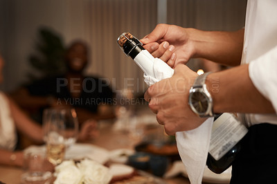 Buy stock photo Champagne, celebration and hand of a man with friends at a party, dinner or new years at the dining room table. Drinks, alcohol and group of people with a bottle to celebrate a holiday together