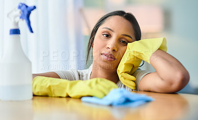 Buy stock photo Shot of a young woman looking tire while cleaning at home
