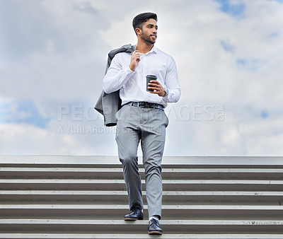 Buy stock photo Shot of a young businessman using a phone in the city