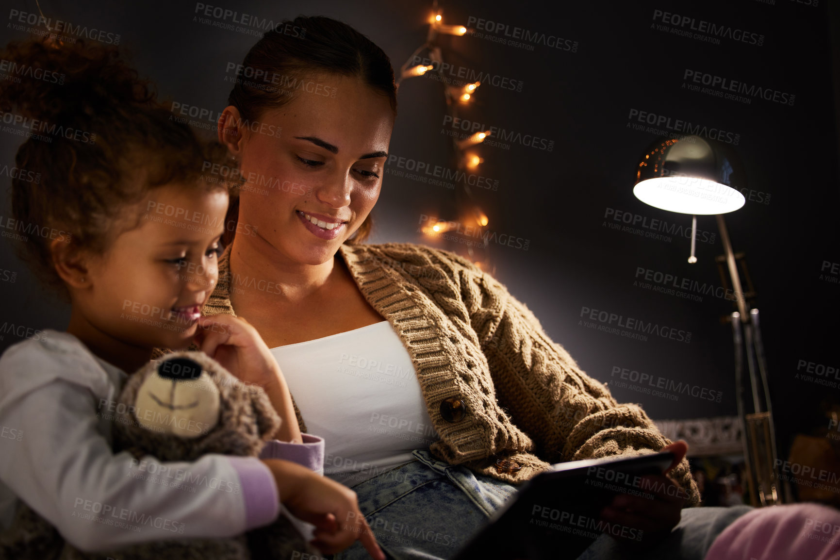 Buy stock photo Mother, girl child and tablet in bed, comfort and storytelling for bed time routine, bonding and love at family home. Woman, daughter and together in bedroom at night with ebook, safety and security