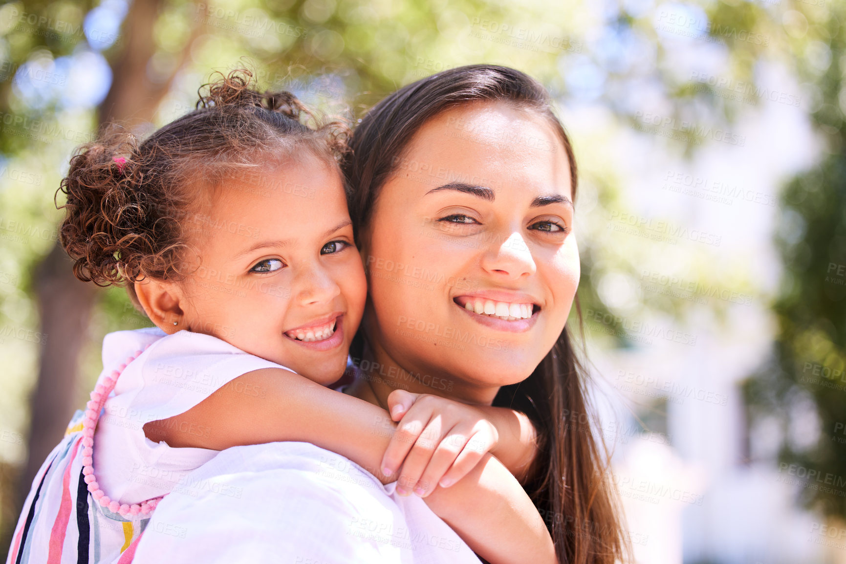 Buy stock photo Shot of a mother giving her daughter a piggyback ride in the park