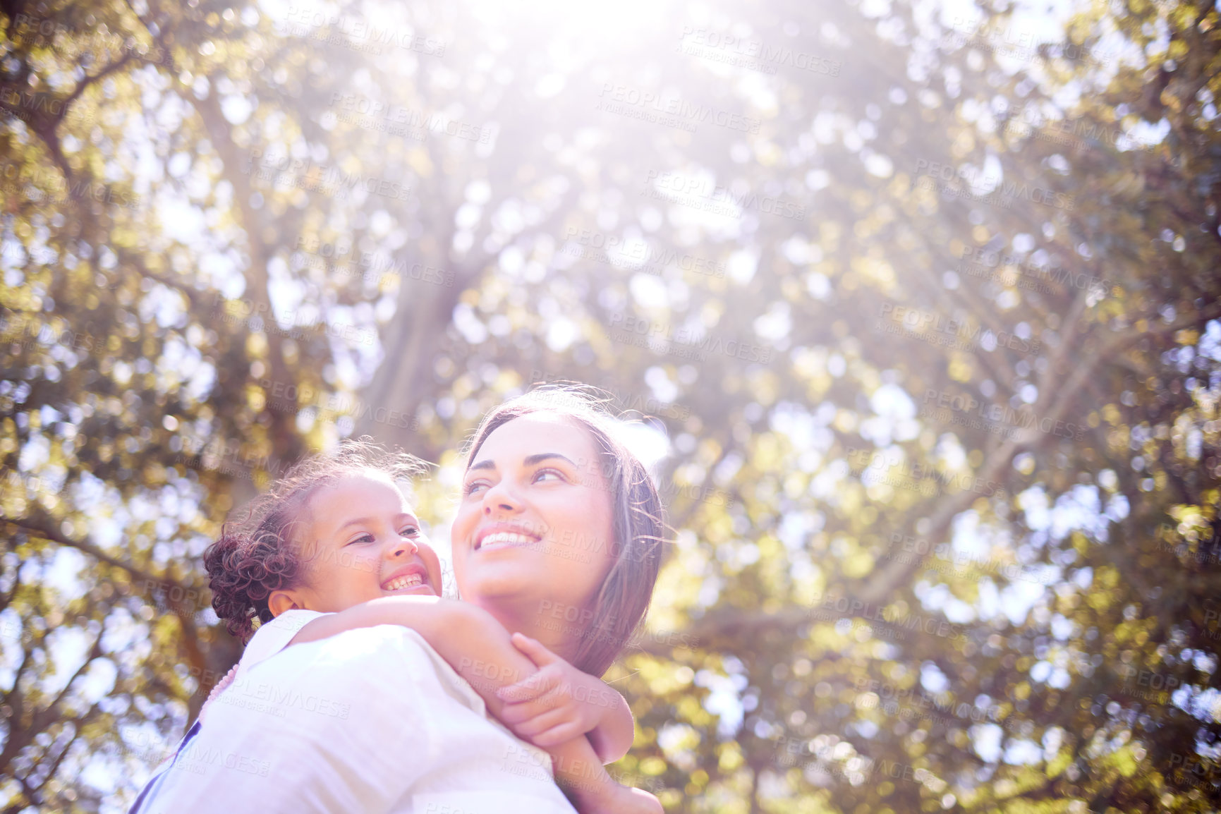 Buy stock photo Shot of a mother giving her daughter a piggyback ride in the park