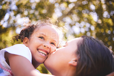 Buy stock photo Mother, child and kiss in nature, smile or bonding on  summer holiday vacation. Mom, kissing cheek and happy girl, love and affection, care and enjoying quality family time together outdoor in park.