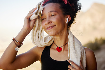 Buy stock photo Shot of a woman using a towel to dry herself after a workout