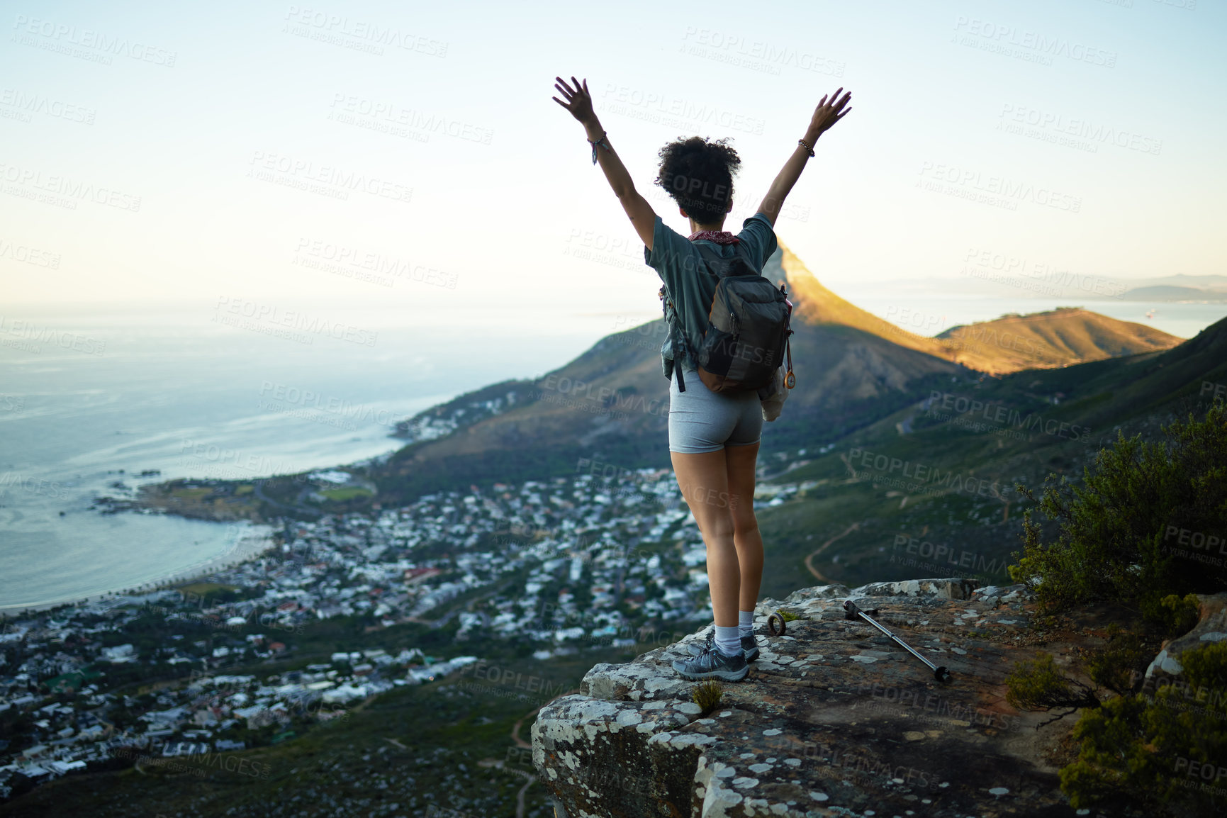 Buy stock photo Shot of a woman standing with her arms outstretched while standing on a mountain cliff