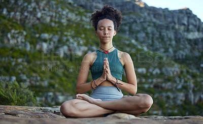 Buy stock photo Shot of a young woman meditating while out in the mountains