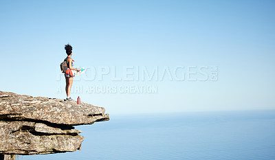 Buy stock photo Shot of a woman holding a map while standing on a mountain cliff