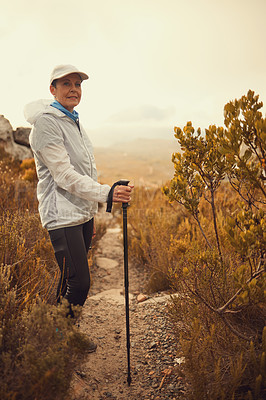 Buy stock photo Trekking pole, hiking and travel with portrait of old woman in nature for wellness, fitness and retirement. Journey, freedom and senior hiker walking in outdoors for environment, adventure or sunrise