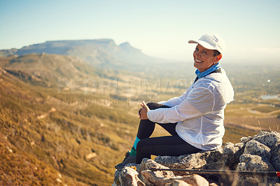 Buy stock photo Shot of a mature woman sitting on a rock in nature