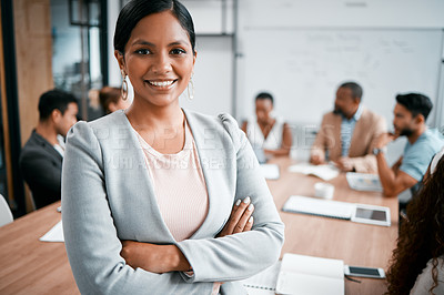 Buy stock photo Cropped portrait of an attractive young businesswoman attending a meeting in the boardroom with her colleagues in the background