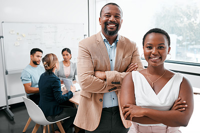 Buy stock photo Cropped portrait of two businesspeople attending a meeting in the boardroom with their colleagues in the background