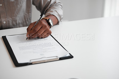 Buy stock photo High angle shot of an unrecognizable businessman filling out a form on a clipboard while sitting at his desk in the office