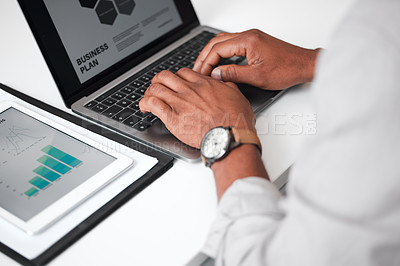 Buy stock photo High angle shot of an unrecognizable businessman using a laptop while sitting at his desk in the office