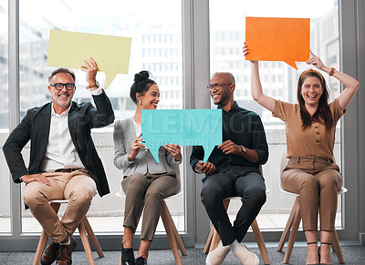 Buy stock photo Shot of a group of young businesspeople holding speech bubbles while waiting in line