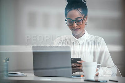 Buy stock photo Cropped shot of an attractive young businesswoman sending a text while working at her desk in the office