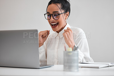 Buy stock photo Cropped shot of an attractive young businesswoman cheering while working on her laptop at a desk in the office