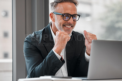 Buy stock photo Cropped shot of a handsome mature businessman cheering while working on his laptop at a desk in the office